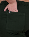 Close up of Juliet's hand in the back pocket of Action Pants in Swamp Green