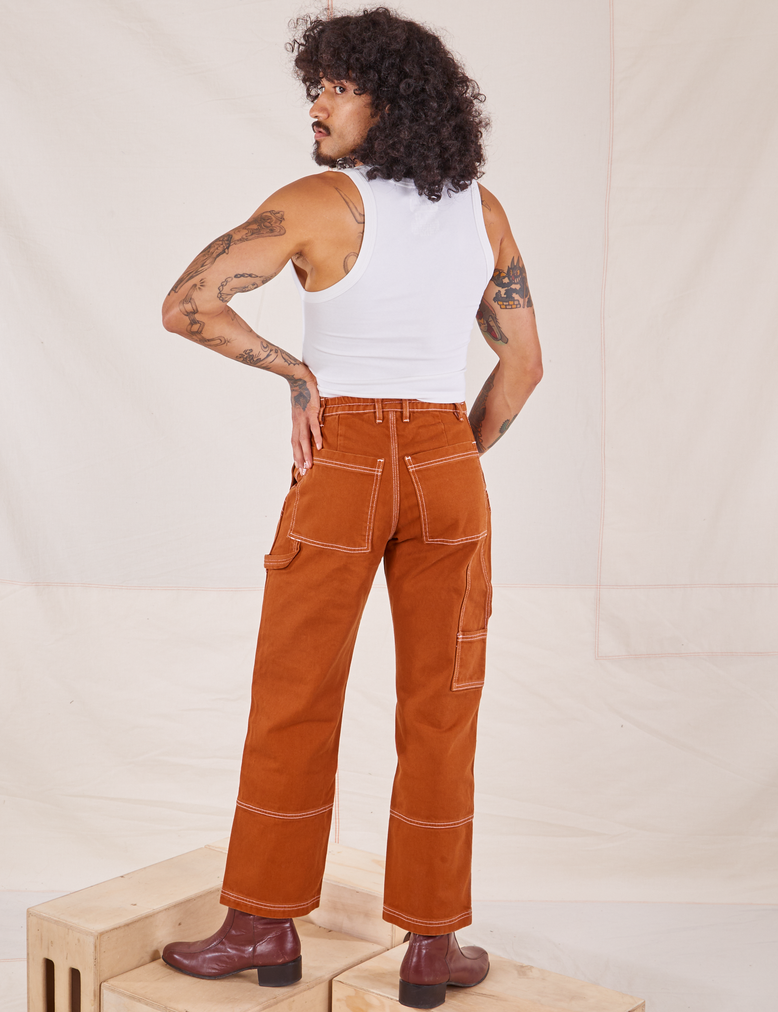 Back view of Carpenter Jeans in Burnt Terracotta and vintage off-white Cropped Tank Top on Jesse