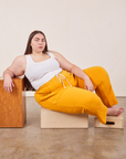 Marielena is wearing Cropped Rolled Cuff Sweatpants in Mustard Yellow and vintage off-white Tank Top