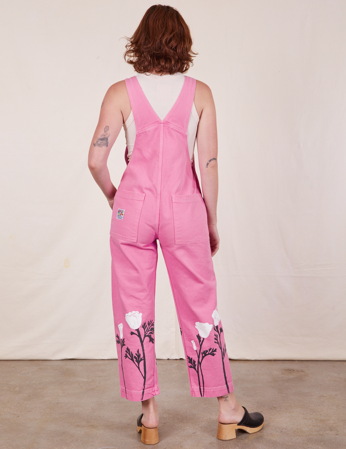Back view of California Poppy Overalls in Bubblegum Pink and vintage off-white Tank Top worn by Alex