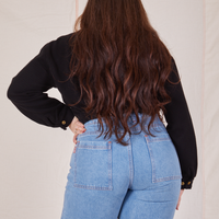 Back view of Ricky Jacket in Basic Black and light wash Sailor Jeans worn by Sydney