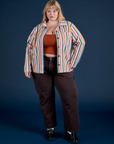 Juliet is wearing Stripe Work Jacket in Rainbow Stripe and espresso brown Work Pants