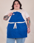 Sam is wearing Full Denim Apron in Royal Blue