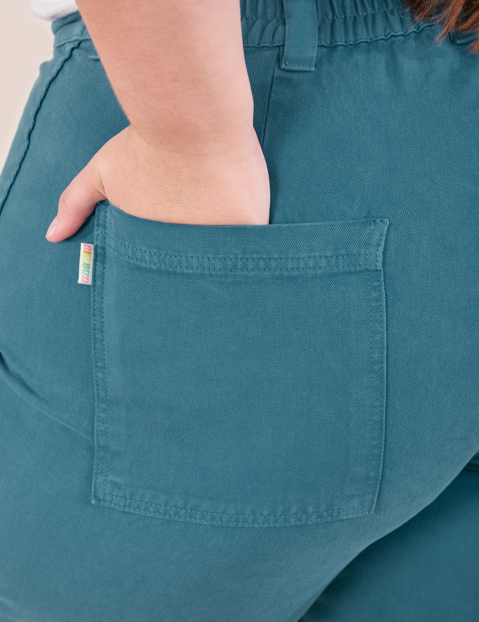Bell Bottoms in Marine Blue back pocket close up. Marielena has her hand in the pocket.