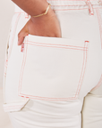 Carpenter Jeans in Vintage Off-White back pocket close up. Meghna has her hand in the pocket.