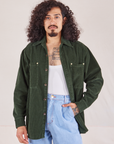 Jesse is wearing Corduroy Overshirt in Swamp Green with a vintage off-white Cropped Tank underneath paired with light wash Denim Trouser Jeans