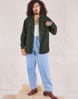 Jesse is wearing Corduroy Overshirt in Swamp Green with a vintage off-white Cropped Tank underneath and light wash Denim Trouser Jeans