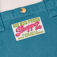 Sun Baby brass snap on Shopper Tote Bag in Marine Blue. Bag label with green and pink text that reads "Big Bud Press Shopper Tote, Made in L.A., 100% Cotton Denim" on white background