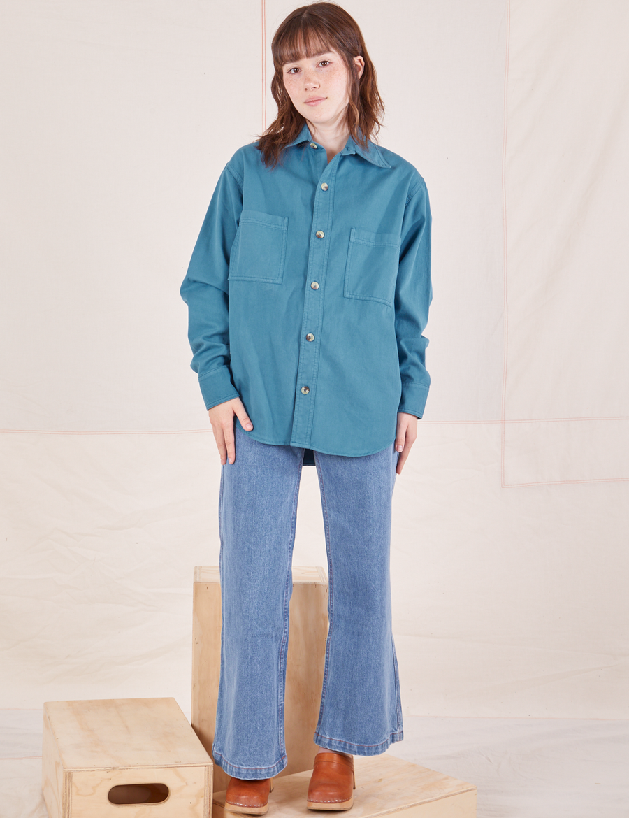Hana is wearing a buttoned up Oversize Overshirt in Marine Blue and light wash Sailor Jeans