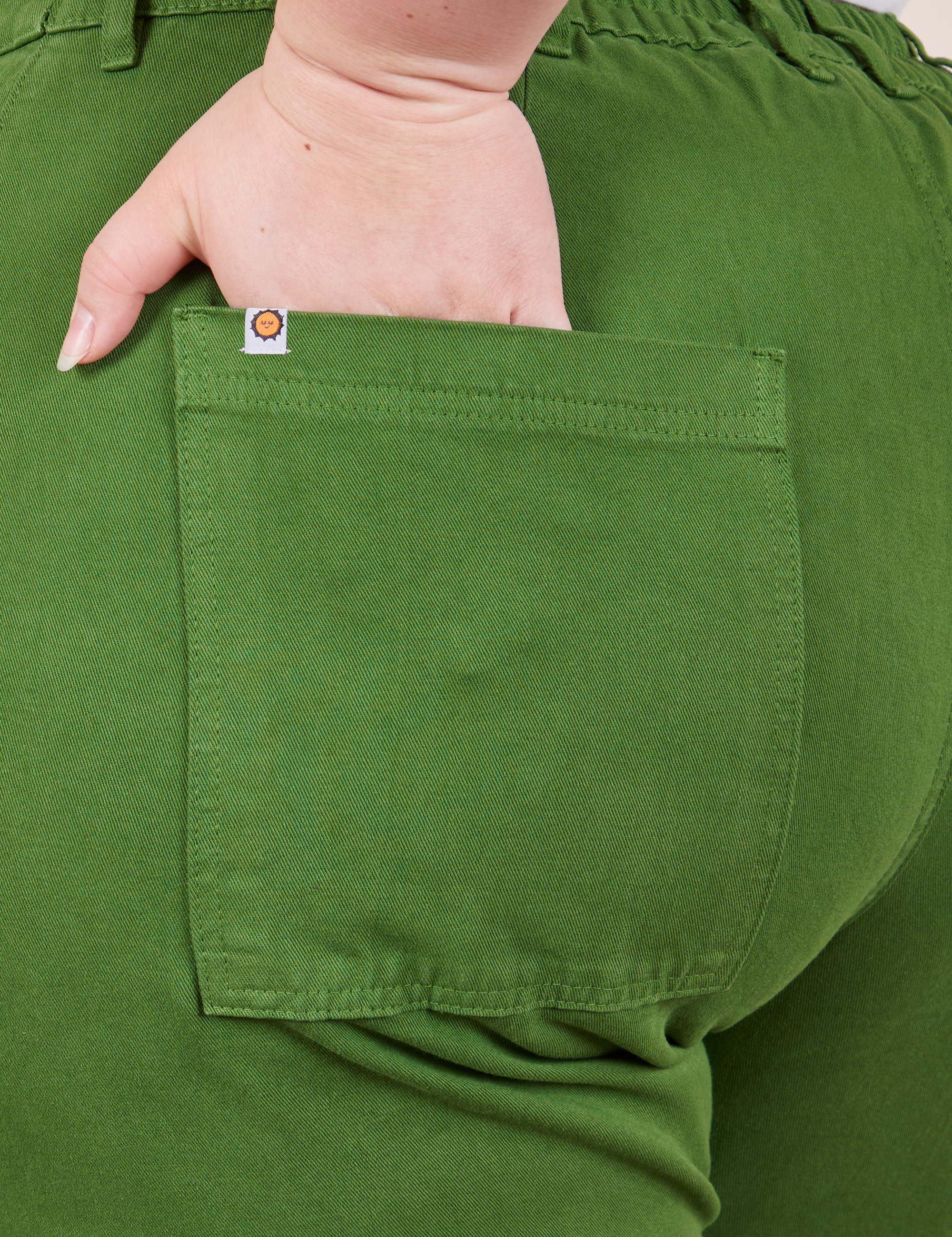 Petite Pencil Pants in Lawn Green back pocket close up. Ashley has her hand in the pocket.
