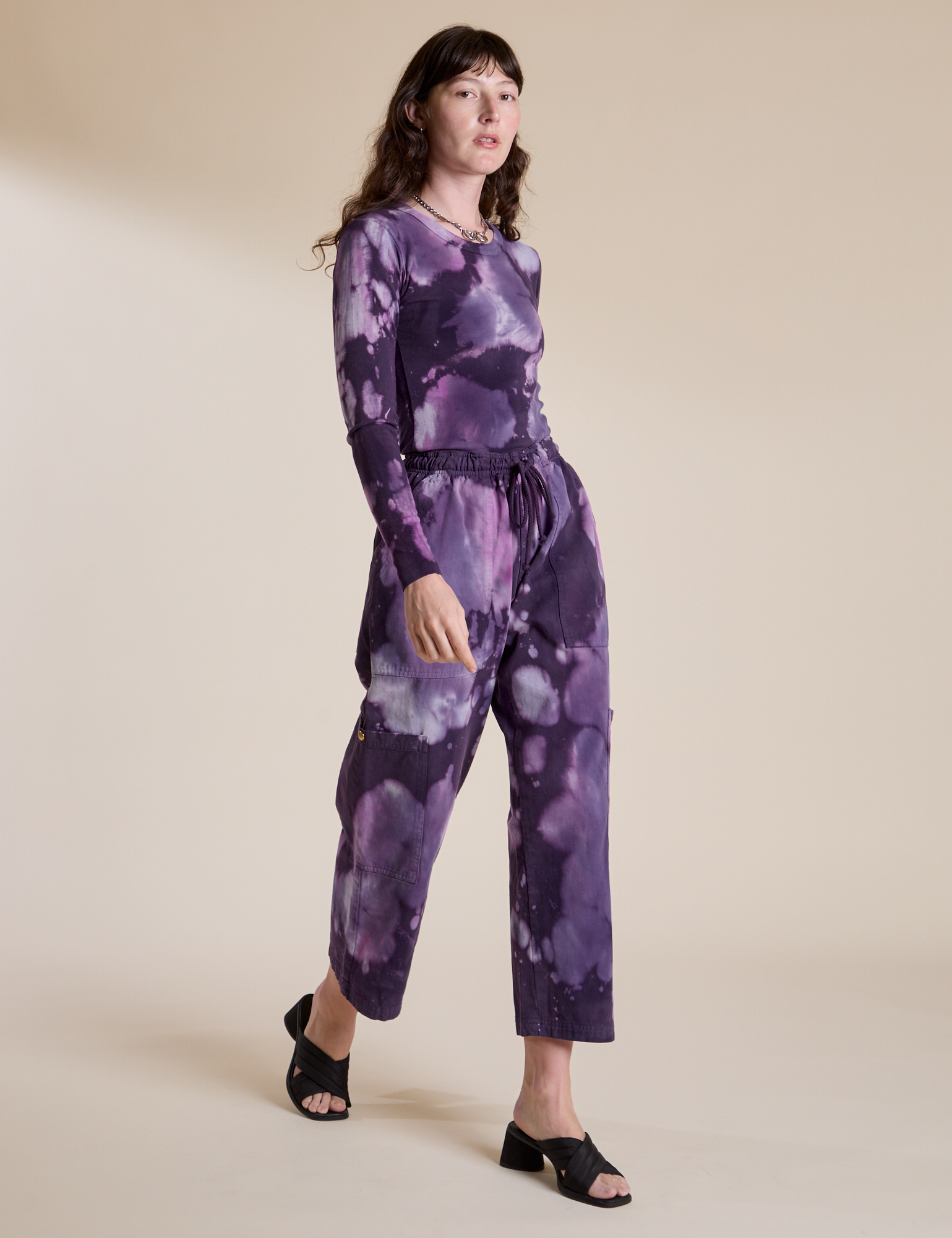 Alex is wearing Magic Waters Drop Pocket Pants in Dark Lavender and matching Long Sleeve Baby Tee