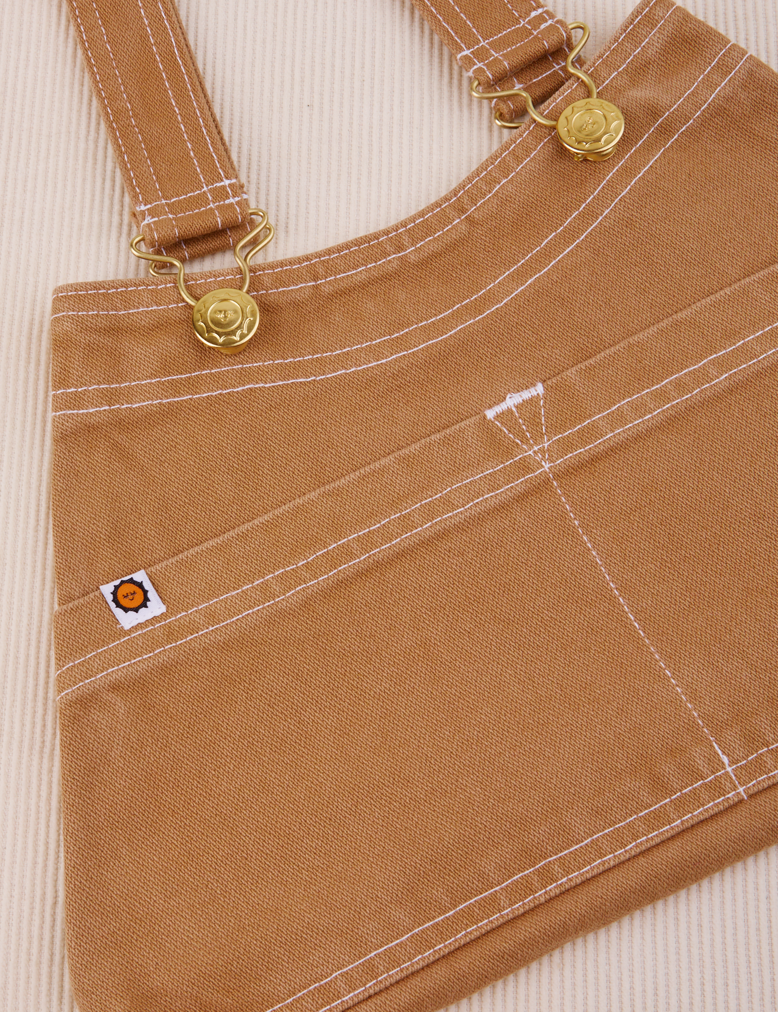 Overall Handbag in Tan. White contrast stitching. Brass sun baby buttons and hardware.