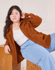 Ashley is wearing Corduroy Overshirt in Burnt Terracotta and light wash Denim Trouser Jeans