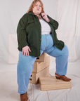 Catie is wearing Flannel Overshirt in Swamp Green, vintage off-white Cropped Tank Top and light wash Trouser Jeans