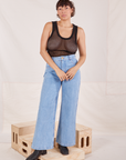 Tiara is wearing Mesh Tank Top in Basic Black tucked into light wash Sailor Jeans