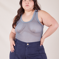 Ashley is 5'7" and wearing L Mesh Tank Top in Periwinkle paired with navy Western Pants