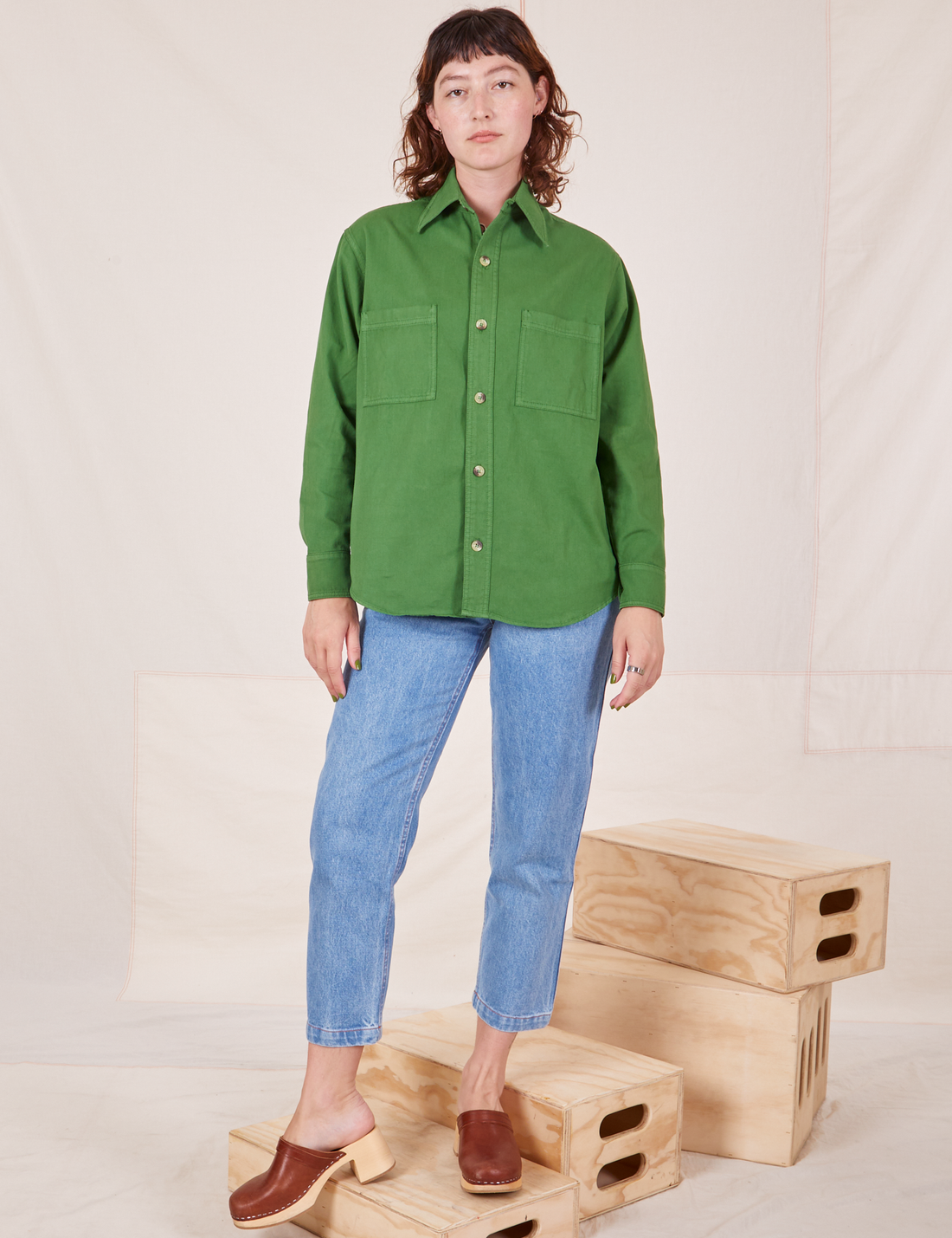 Alex is wearing a buttoned up Oversize Overshirt in Lawn Green and light wash Frontier Jeans
