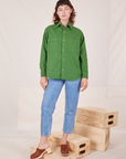 Alex is wearing a buttoned up Oversize Overshirt in Lawn Green and light wash Frontier Jeans