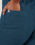 Petite Western Pants in Lagoon back pocket close up. Kandia has her hand in the pocket.