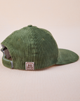 Side view of Dugout Corduroy Hat in Emerald Green. Big Bud label sewn on edge of hat.