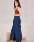 Side view of Indigo Wide Leg Trousers in Dark Wash and burnt terracotta Cropped Cami on Hana