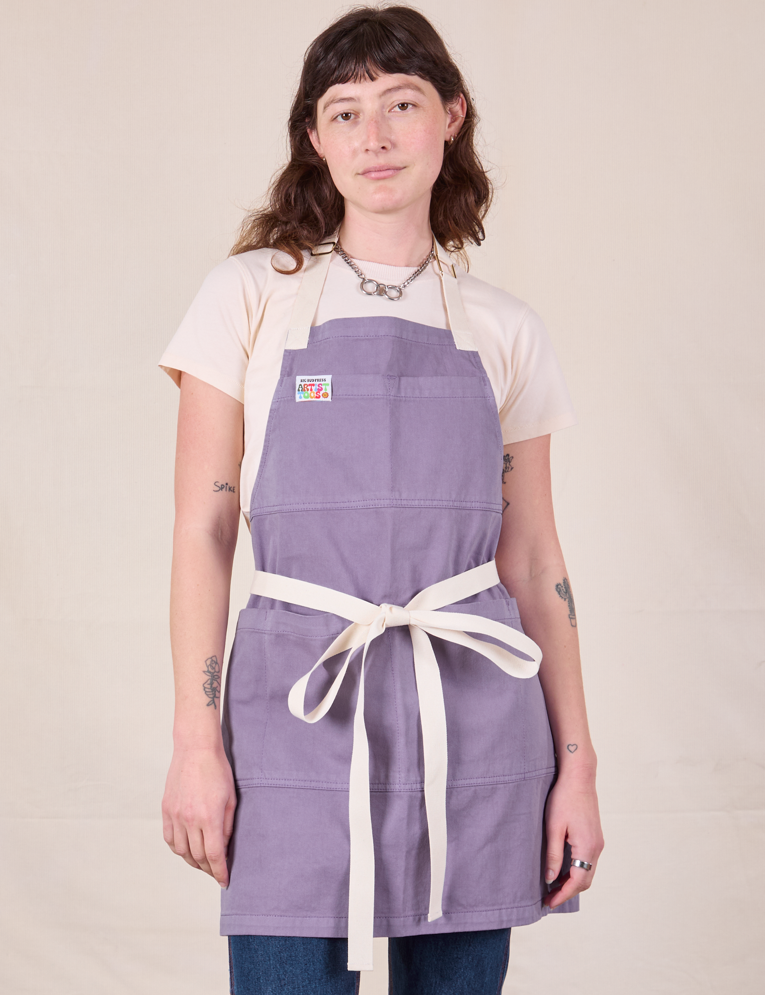 Alex is wearing Full Denim Apron in Faded Grape