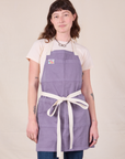 Alex is wearing Full Denim Apron in Faded Grape