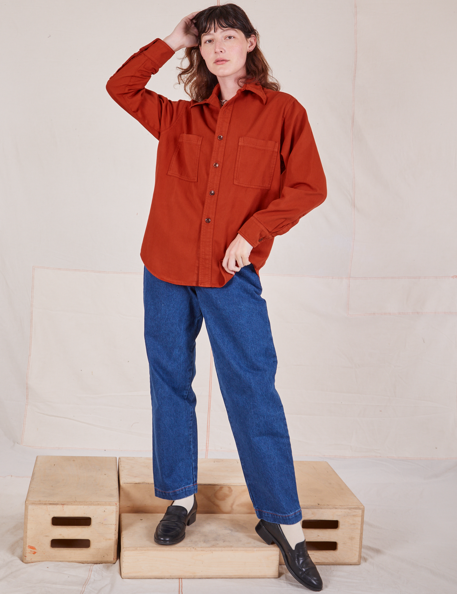 Alex is wearing a buttoned up Oversize Overshirt in Paprika and dark wash Trouser Jeans