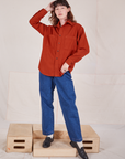 Alex is wearing a buttoned up Oversize Overshirt in Paprika and dark wash Trouser Jeans