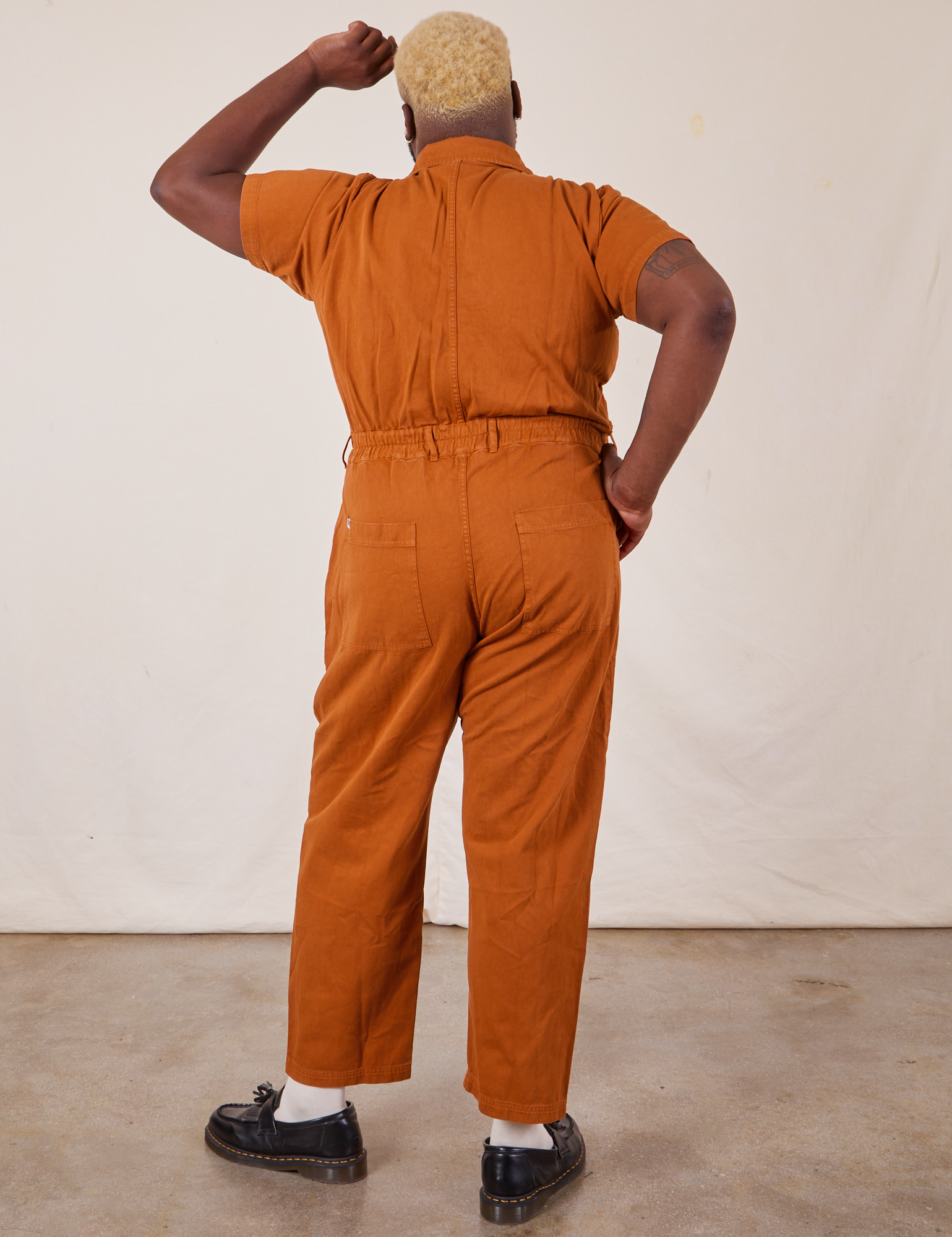 Back view of Short Sleeve Jumpsuit in Burnt Terracotta worn by Elijah