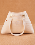 Overall Handbag in Vintage Off-White. Handle strap hanging down front of bag