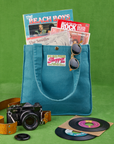 Shopper Tote Bag in Marine Blue with records and books inside. Camera sits in front of bag.