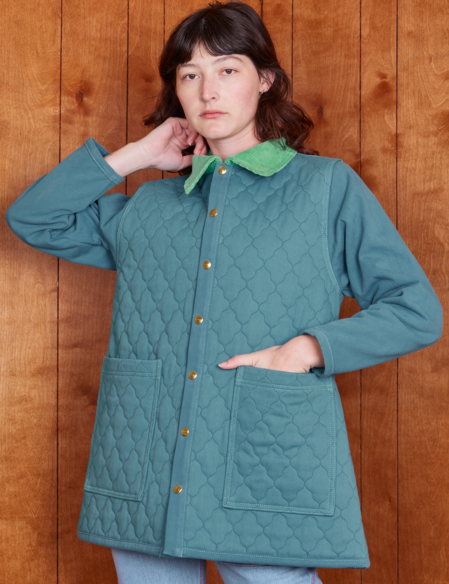 Alex is wearing a buttoned up Quilted Overcoat in Marine Blue