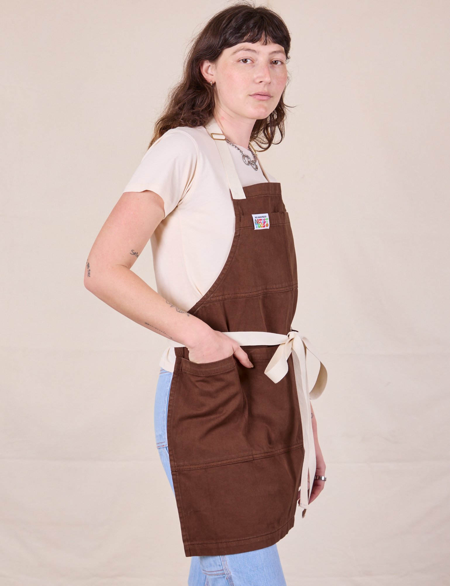 Side view of Full Denim Apron in Fudgesicle Brown on Alex