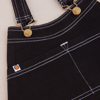 Overall Handbag in Black. White contrast stitching. Brass sun baby buttons and hardware