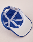 Dugout Corduroy Hat in Royal Blue flipped over. White satin under-bill