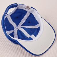 Dugout Corduroy Hat in Royal Blue flipped over. White satin under-bill