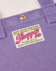 Sun Baby brass snap on Shopper Tote Bag in Faded Grape. Bag label in green and pink text that reads "Big Bud Press Shopper Tote, Made in L.A., 100% Cotton Denim" on a white background