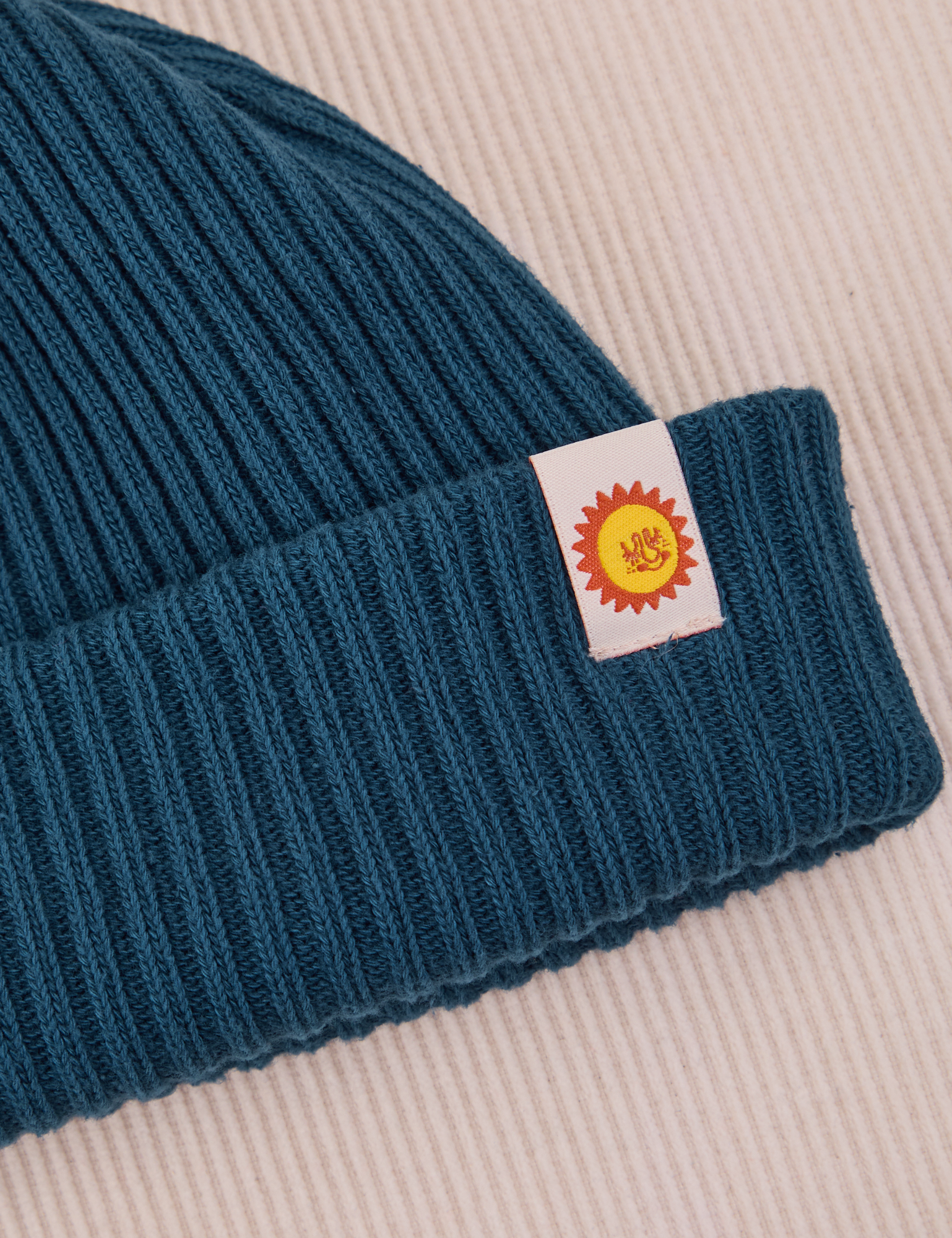 Ribbed Beanie in Lagoon close up of sun baby tag