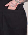 Close up of Sam's hand in the pocket of the Full Denim Apron in Basic Black