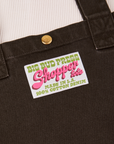 Sun Baby brass snap on Shopper Tote Bag in Espresso Brown. Bag label with green and pink text that reads "Big Bud Press Shopper Tote, Made in L.A.,100% Cotton Denim" on white background