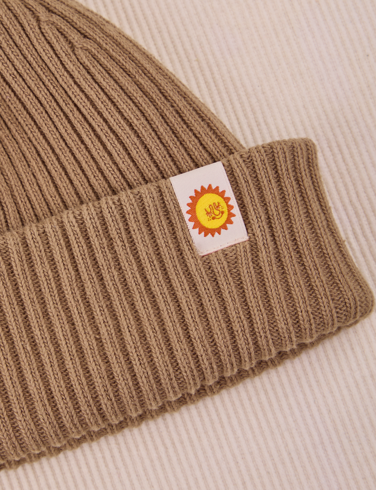 Ribbed Beanie in Desert Brown close up of sun baby tag