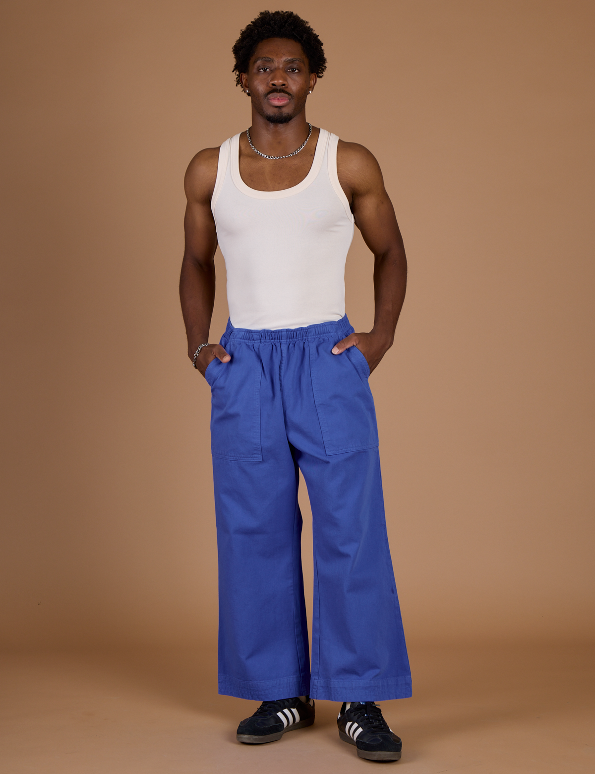 Isaac is 5'10" wearing M Cornflower Blue Action Pant with Vintage Tee Off-White Tank Top