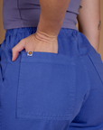 Close up of Alex's hand in the back pocket wearing the Cornflower Blue Action Pant