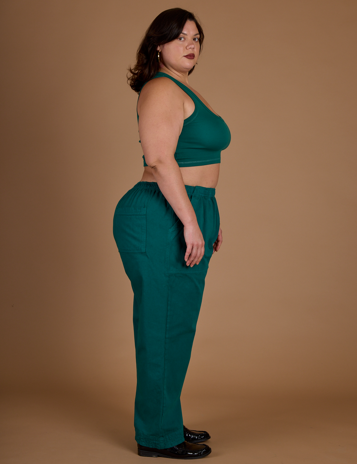 Side view of Kristen wearing the Hunter Green Action Pant