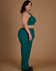 Side view of Kristen wearing the Hunter Green Action Pant