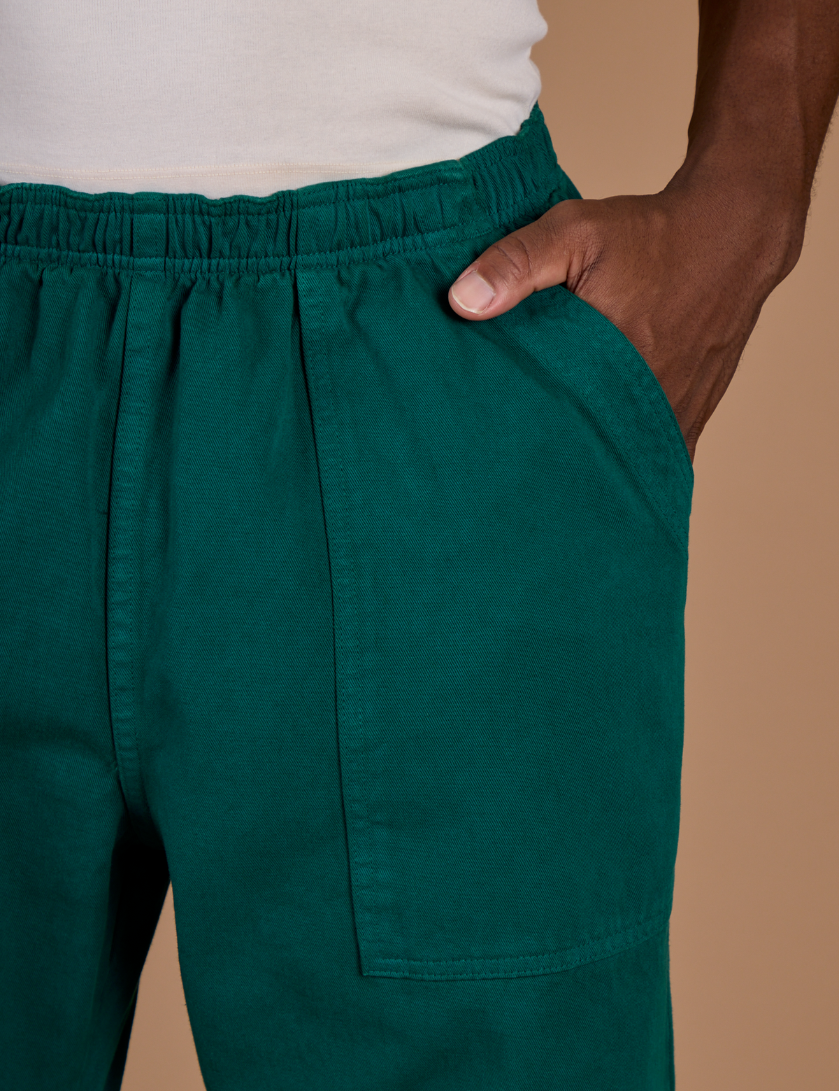 Close up of the Hunter Green Action Pant with Isaac's hand in the front pocket