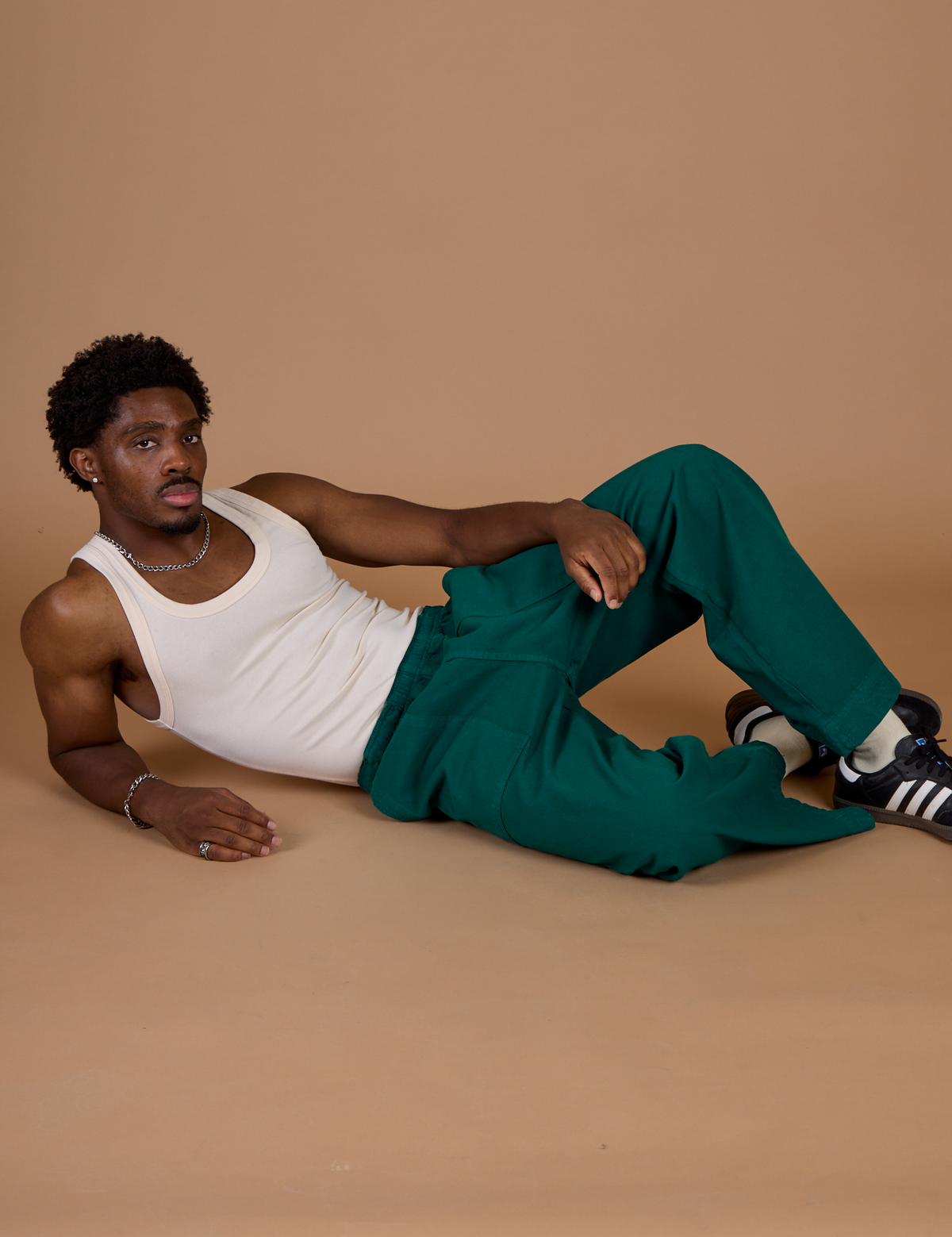 Isaac wearing the Hunter Green Action Pant with the Vintage Tee Off-White Tank Top