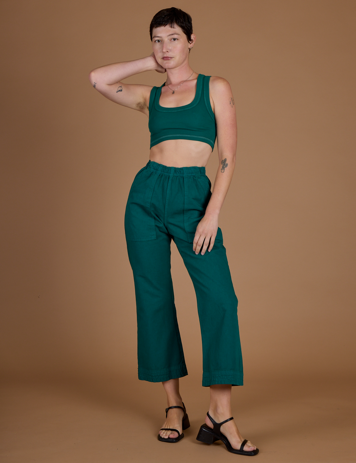 Alex is 5'8" and wearing XXS Hunter Action pant with the Hunter Green Mini Tank