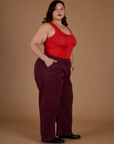 Angled side view of Kristen wearing the Red Wine Action Pant